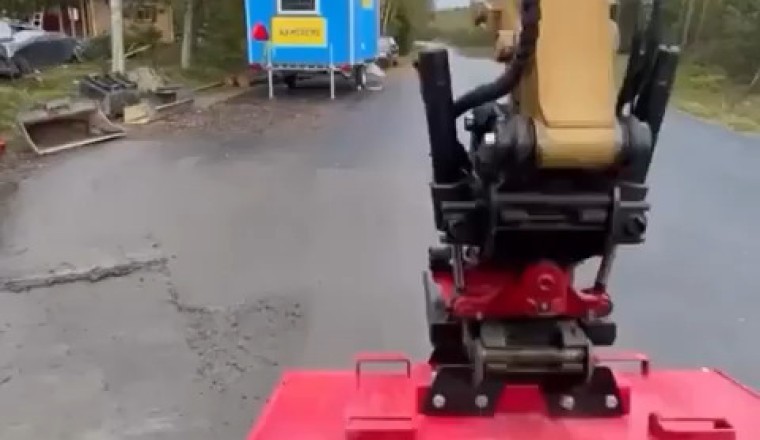 Excavator Sweeping Road with Brush Attachment: Efficient Street Cleaning in Action