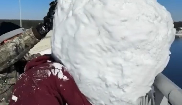 Watch a Massive Snow Block Plunge into the Water from a Bridge!